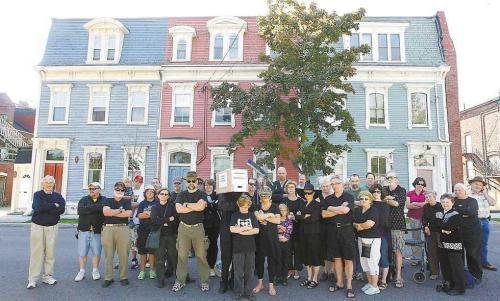 Photo by Noel Chenier. A group of residents concerned about the loss of the jelly bean buildings on Wellington Row wear black at a gathering on Sunday. 